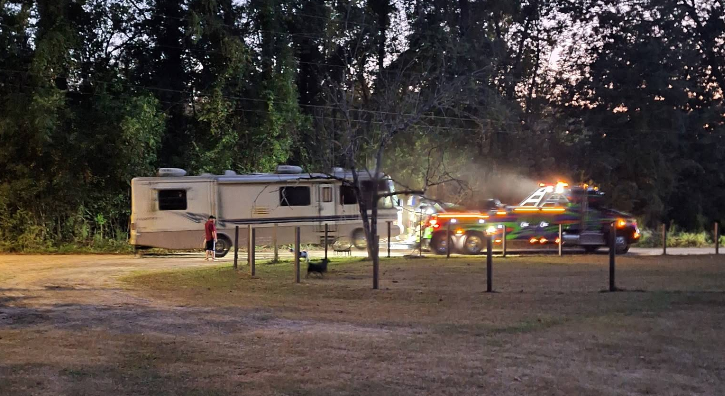 Mack's Towing truck assisting an RV at dusk